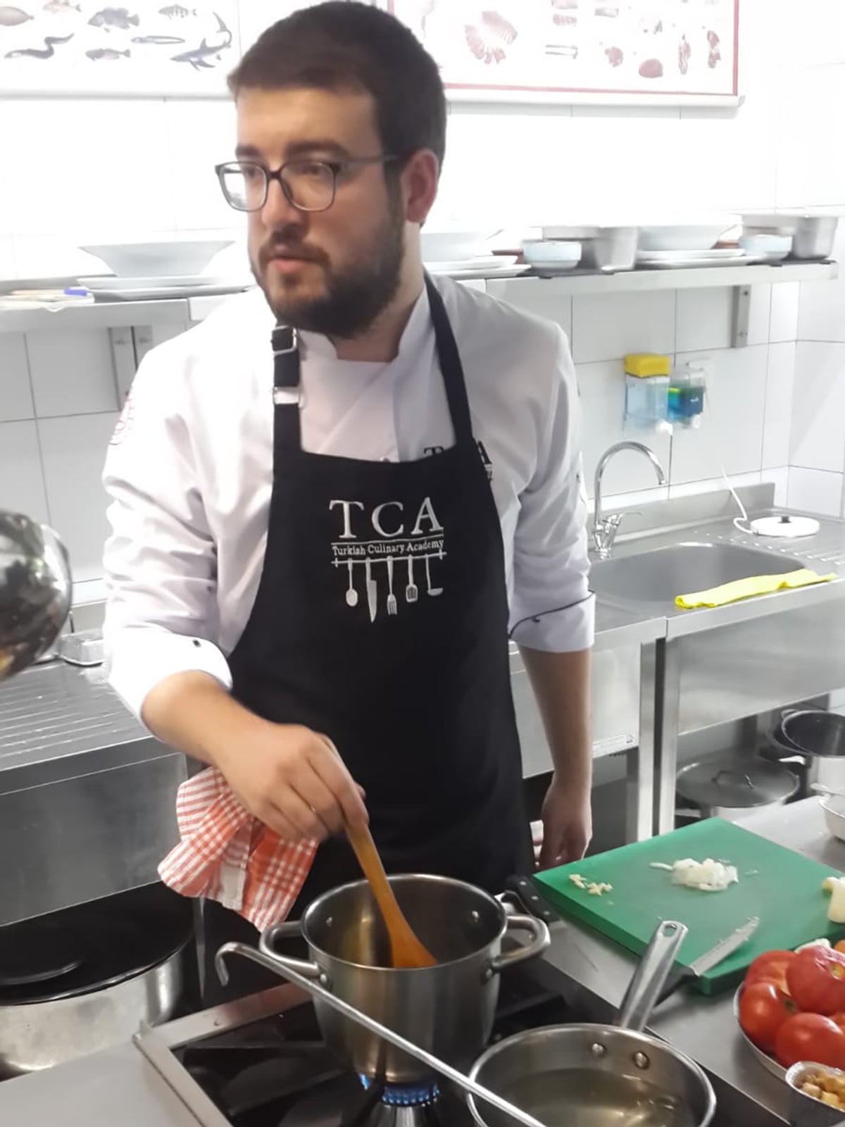 Emin cooking during a culinary school final exam.